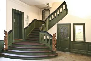 una escalera en una casa con una puerta verde en Hotel Anno 1216, en Lübeck