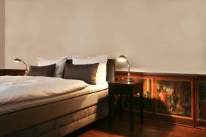 a bedroom with a bed and a table with a painting at Hotel Anno 1216 in Lübeck