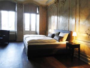 a bedroom with a large bed and two windows at Hotel Anno 1216 in Lübeck +6 photos