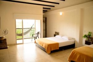 a bedroom with a bed and a balcony at Finca Hotel Loma Verde in Quimbaya