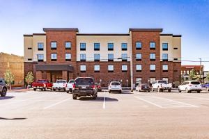 um parque de estacionamento com carros estacionados em frente a um edifício em Cobblestone Hotel & Suites - Superior Duluth em Superior