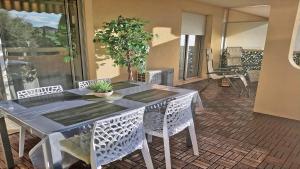 stół i krzesła w salonie z rośliną w obiekcie Patio Fleuri w miejscowości Sainte-Maxime