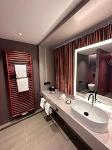 a bathroom with a sink and a large mirror at Apartment-Hotel Hamburg Mitte in Hamburg