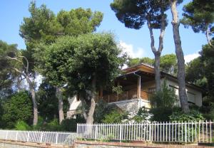 a house behind a white picket fence at La Casa di Ulisse B&B in Quercianella