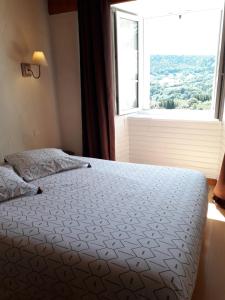 una camera da letto con un letto e una grande finestra di Maison avec 2 chambres est un Gîte Brugière et maison une chambre est une chambre d'hôtes a Murat-le-Quaire