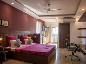 um quarto com uma cama e uma cadeira num quarto em Perch Service Apartment DLF Cyber City em Gurgaon