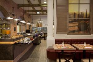 a restaurant kitchen with tables and chairs at Estilo Fashion Hotel Budapest in Budapest