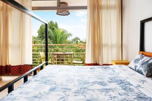 een slaapkamer met een bed en een groot raam bij Bushpig Backpacker Hostel in Kampala