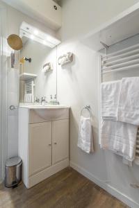 W łazience znajduje się umywalka i lustro. w obiekcie Florella Jean Jaures Apartment w Cannes