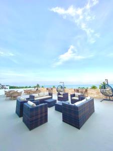 若昂佩索阿的住宿－Nobile Suítes Tambaú，一组蓝色沙发,位于一个享有海景的庭院