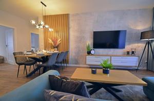 een woonkamer met een tafel en een tv bij Osiedle Platan - Apartamenty Bryza - Centrum in Świnoujście