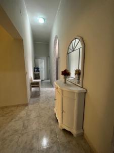un corridoio con un comò con uno specchio sopra di L’angolo rosa a Carosino