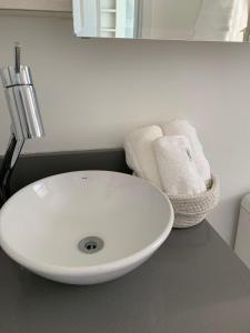 a bathroom with a white sink and towels on a counter at Encanto dos Mares - Apartamento premium 4 in Camboriú