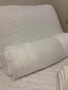 un letto bianco con un cuscino sopra di Encanto dos Mares - Apartamento premium 4 a Camboriú