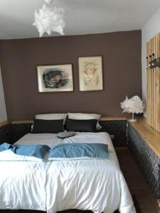 a bedroom with a large bed with two pictures on the wall at Heimat Floral Ferienwohnung in Wadgassen