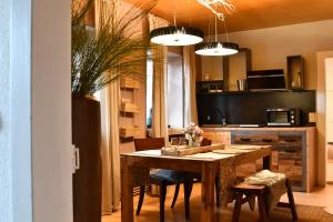 a kitchen with a wooden table and chairs in a room at Heimat Floral Ferienwohnung in Wadgassen