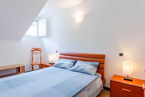een slaapkamer met een bed met blauwe lakens en 2 lampen bij Ca’ Maria Vittoria in Turijn