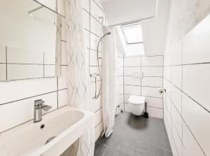 a white bathroom with a sink and a toilet at Tolstov Apartments - 4 Room Apartments - 30 Min Messe DUS in Duisburg +35 photos