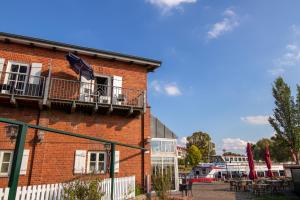 a brick building with a balcony with an umbrella on it at Modernes Appartement am See in Waren