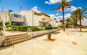 a building with palm trees in front of a sidewalk at Awesome Apartment In Playa Honda With Kitchen in Playa Honda