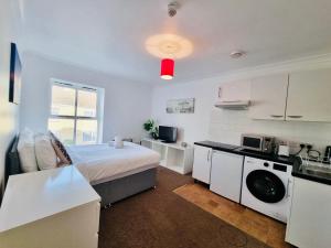 a small room with a bed and a kitchen at Midewell Court by Kasar Stays in Otford