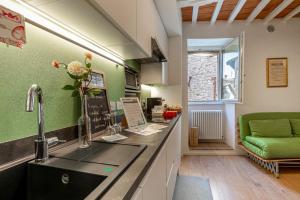 uma cozinha com um lavatório e um sofá verde em Dimora Casina dell'abbondanza em Gubbio