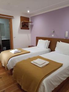 2 Betten in einem Hotelzimmer mit Handtüchern darauf in der Unterkunft Martim Moniz 28 Guest House in Lissabon