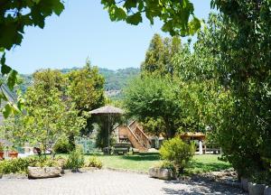un jardín con mesa y sombrilla en Quinta Da Porta Caseira, en Resende