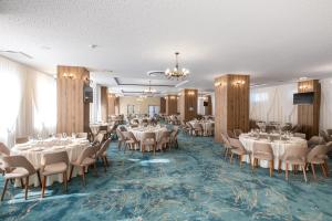 a banquet room with tables and chairs and a chandelier at Fiald Hotel & Spa in Bacău