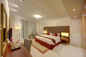 a hotel room with a large bed and a desk at Al Manar Grand Hotel Apartment in Dubai +31 photos
