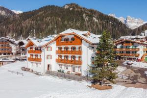 un immeuble d'appartements dans un complexe en montagne dans l'établissement Albergo Canazei, à Canazei