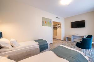 a hotel room with two beds and a television at Fiald Hotel & Spa in Bacău