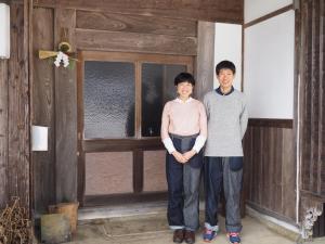 two people standing in front of a room with a window at 一汁一菜の宿　ちゃぶダイニング Ichiju Issai no Yado Chabu Dining Unforgettable Farmstay experience in Deep Kyoto in Ayabe