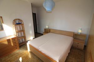 a bedroom with a white bed and wooden furniture at Residence Schubert in Lignano Sabbiadoro +58 photos