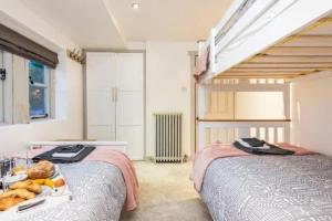 a bedroom with two beds with a tray of food on a tray at Dreamwood Cottage Luxury Hottub Retreat in Crigglestone