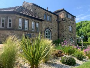an old stone house with a garden in front of it at Dreamwood Cottage Luxury Hottub Retreat in Crigglestone