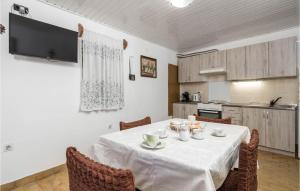 a dining room with a table and chairs and a kitchen at Amazing Home In Susak With Kitchen in Susak