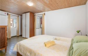 een slaapkamer met een bed met een gele handdoek erop bij Amazing Home In Susak With Kitchen in Susak