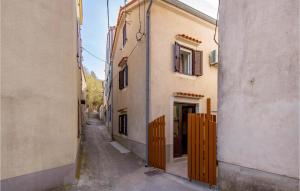 een steegje tussen twee gebouwen met een houten hek bij Amazing Home In Susak With Kitchen in Susak