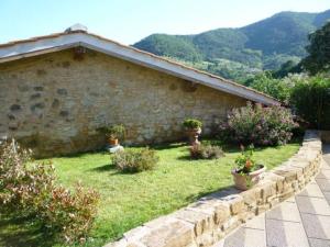 einen Garten mit Topfpflanzen vor einem Steingebäude in der Unterkunft Agriturismo Casa Belvedere in Bacchereto