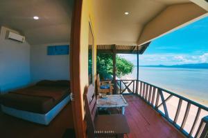 um quarto com uma varanda com vista para a água em Golden Beach Resort Koh Phangan em Ban Tai