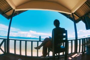 班泰的住宿－帕岸島金灘度假酒店，坐在椅子上,望着大海的人