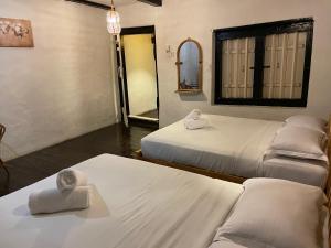 a room with three beds and a mirror at Layang Layang Guest House Melaka in Malacca
