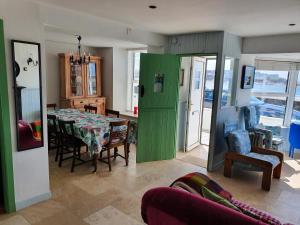 a living room with a table and a green door at Sea Warrior Cottage in Kilkee