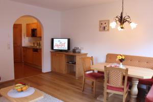 a living room and kitchen with a table and a television at Apart Andrea in Holzgau