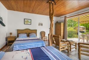 um quarto com uma cama, uma cadeira e uma janela em La ferme de Piardiere em Plessé