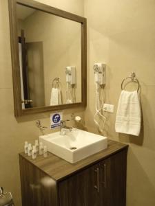 a bathroom with a sink and a mirror at Hotel Raymipampa in Cuenca