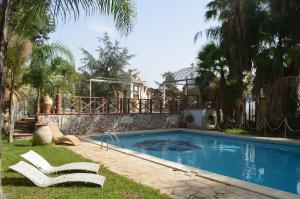 einen Pool mit zwei Liegestühlen neben einem Haus in der Unterkunft Villa Rubino in Catania