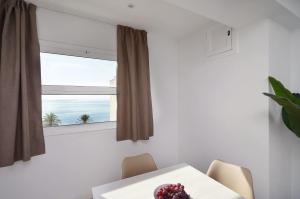 uma sala de jantar com uma mesa e uma janela em Apartamentos Venecia em Lloret de Mar