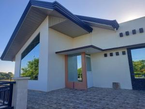 une maison blanche avec une grande porte en verre dans l'établissement Marino Transient House, à Alaminos